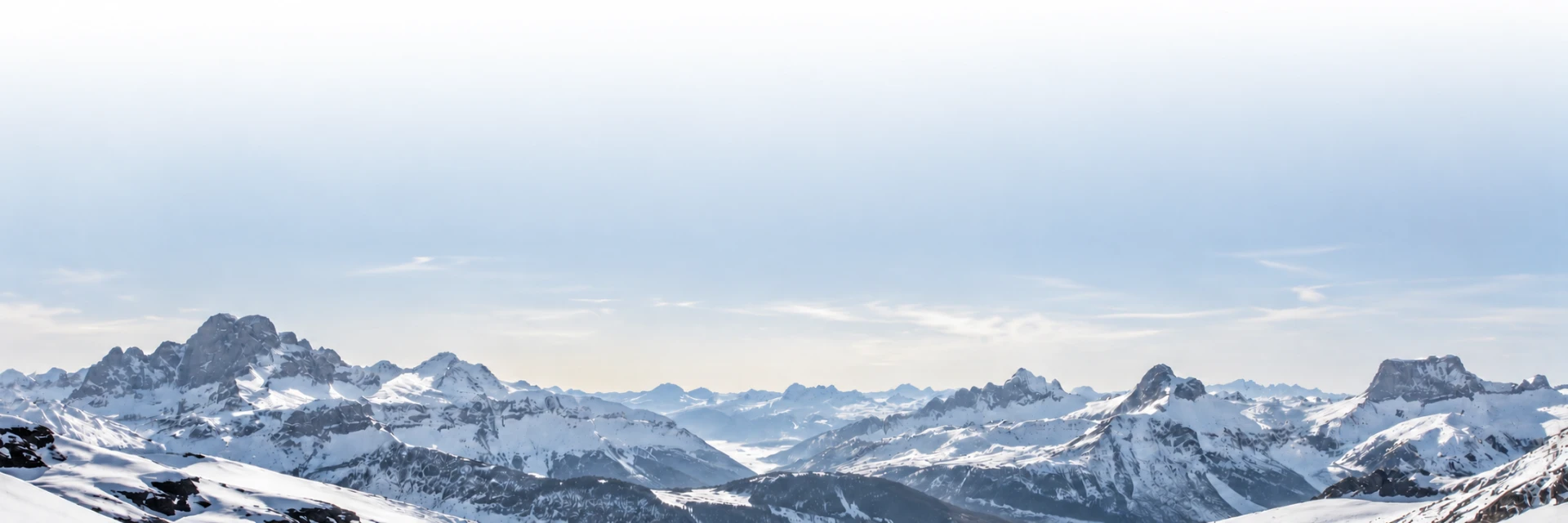 Snowy alpine panorama under a soft sky